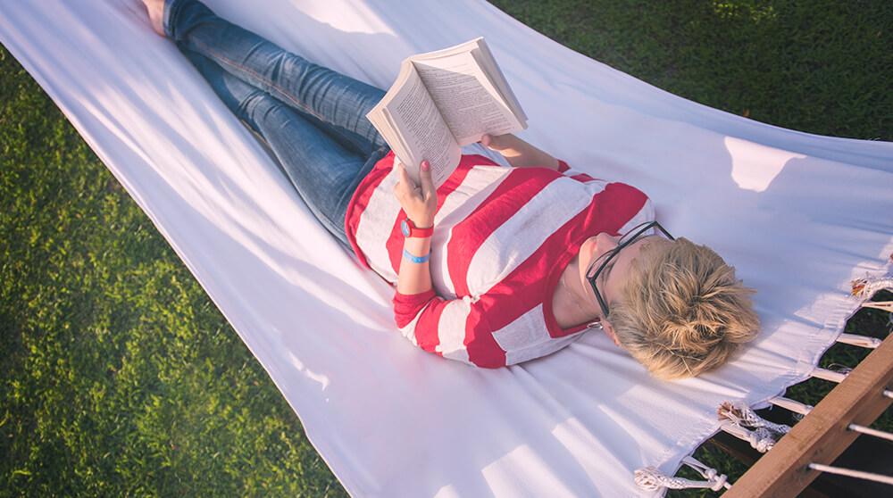 Personne lisant un livre dans un hamac