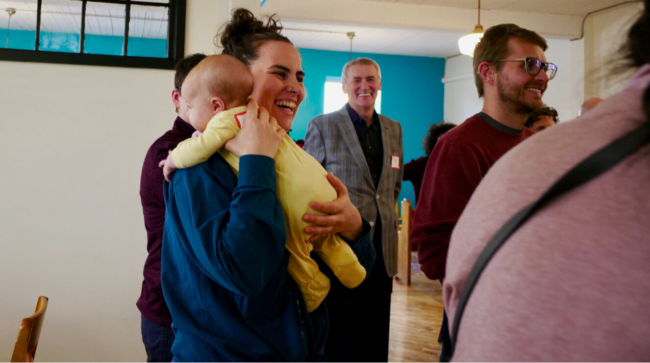 Maman souriante avec son bébé dans ses bras